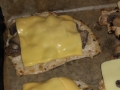 Kotlety schabowe w panierce cebulowej z pieczarkami i żółtym serem.