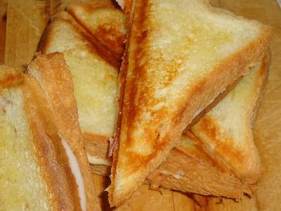Domowe tosty z wędliną i żółtym serem.